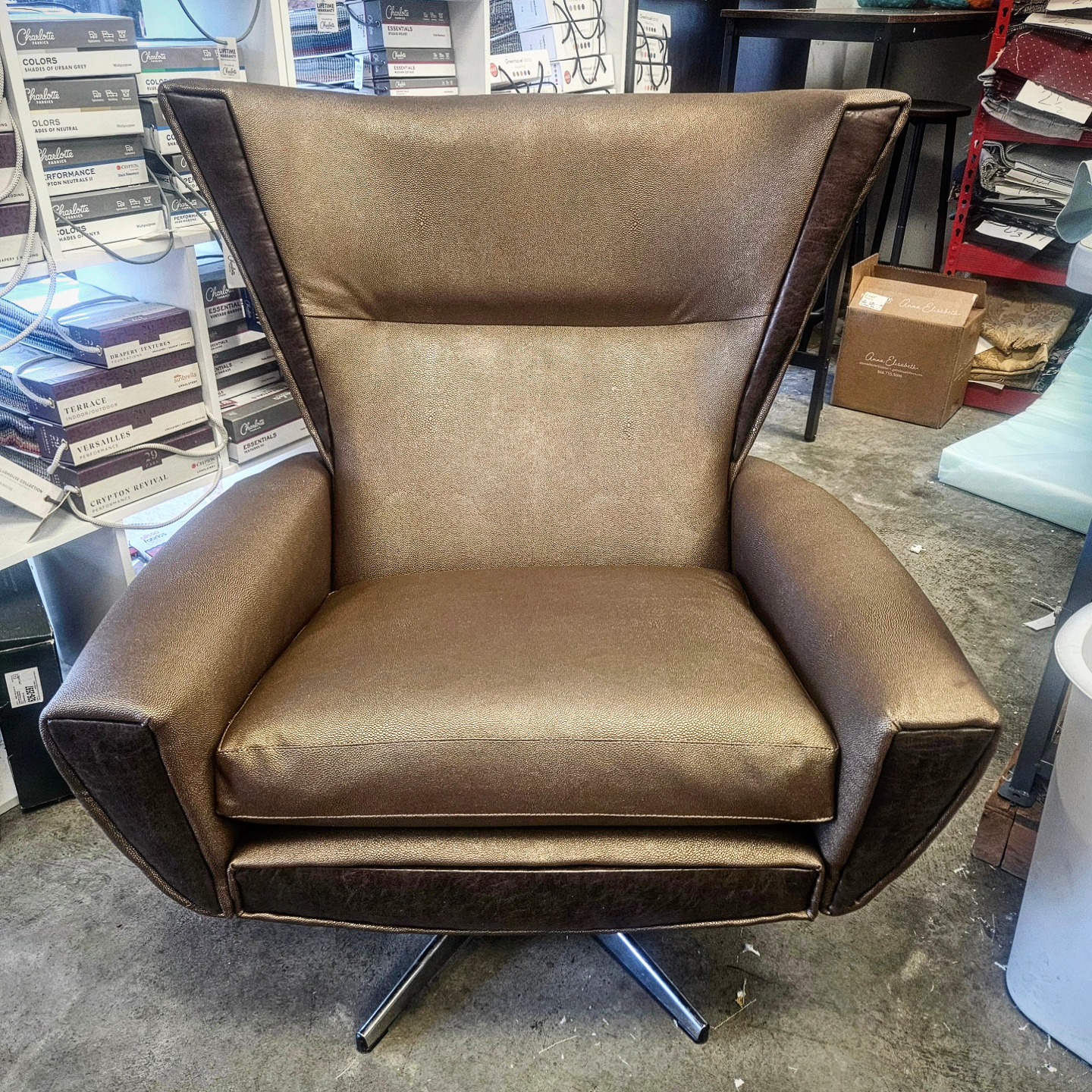 Bronze leather wing chair on a swivel base, reupholstered
