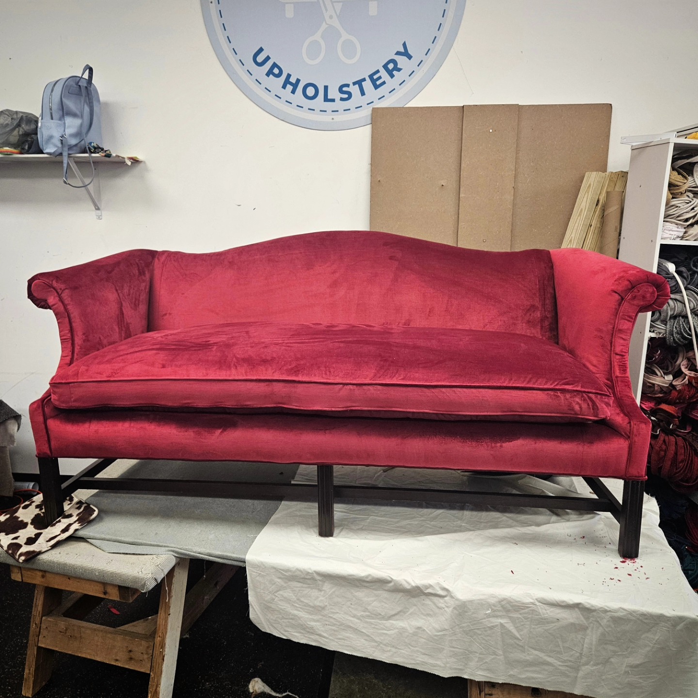 Camelback sofa in deep red velvet, finished in our Clemmons shop